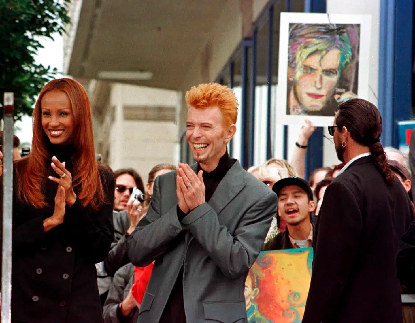 Rock singer David Bowie (R) is shown with his wife Iman (L) with a crowd of Bowie's fans behind them prior to ceremonies honouring Bowie with a star on the Hollywood Walk of Fame in this February 12, 1997 file photo. Singer Bowie has died after an 18-month battle with cancer, his official Twitter account announced on January 11, 2016. REUTERS/Fred Prouser/Files