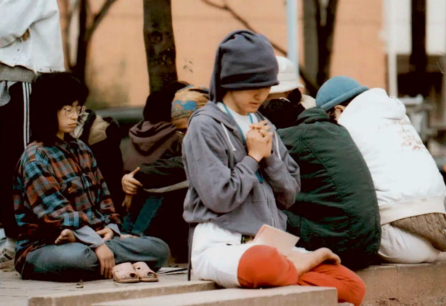 Disciple af 'Sandhedens lære' i bøn efter, at politiet fjernede dem fra en af de ejendomme, der tilhørte sekten.