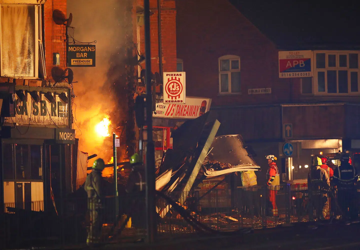 Redningsarbejdere leder efter personer i det sammenstyrtede hus.