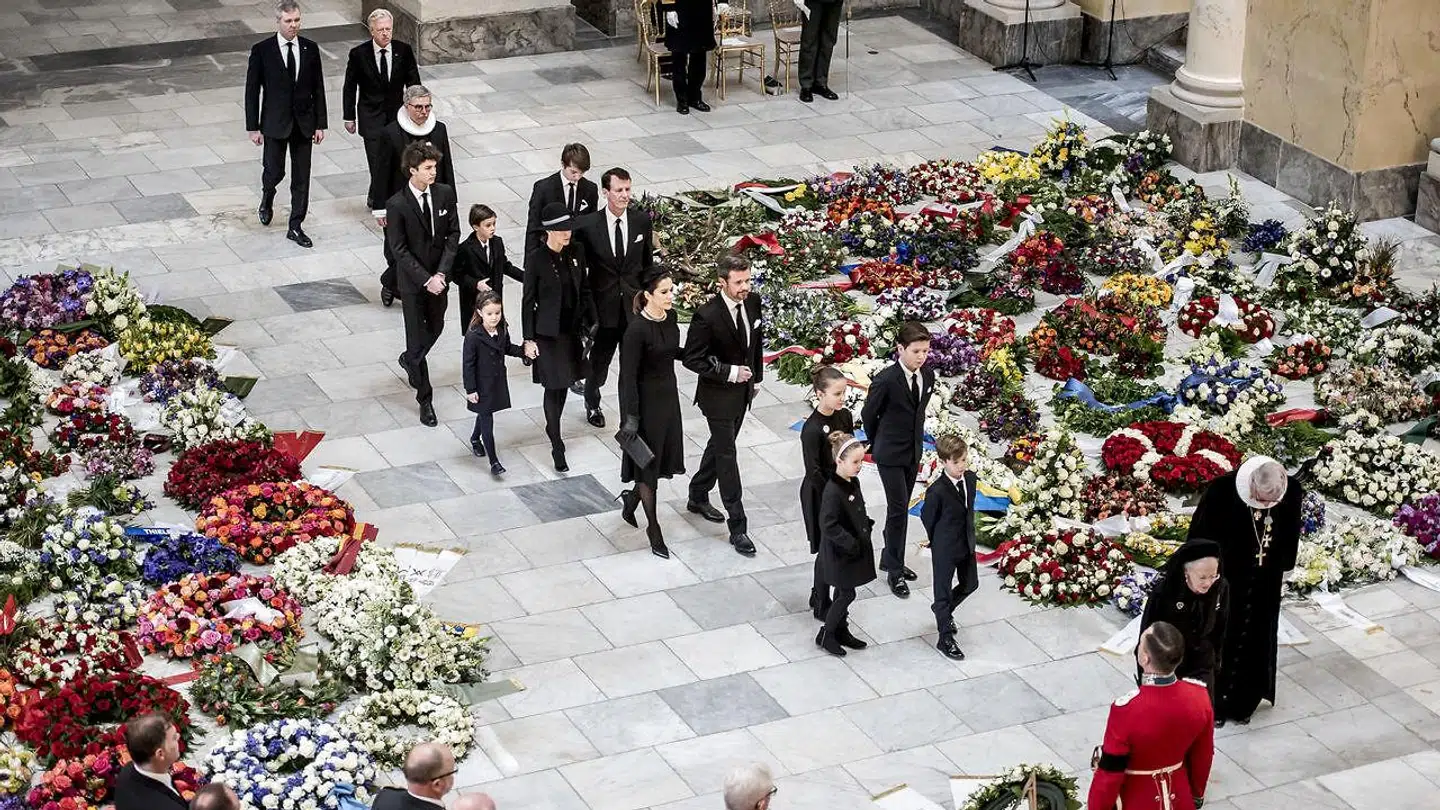 Kongefamilien ankommer til Prins Henriks bisættelse fra Christiansborg Slotskirke i København. Her går de mellem de mange blomster.