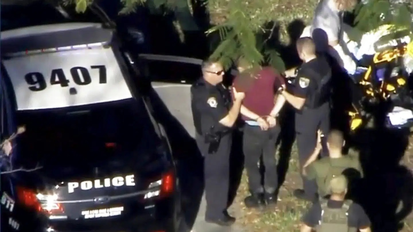 Den formodede gerningsmand bliver fastholdt af politiet nær Marjory Stoneman Douglas High School efter skoleskyderiet i Parkland, Florida.