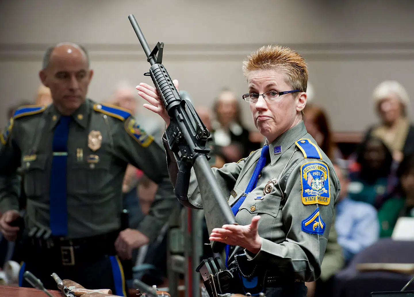 En detektiv holder en Bushmaster AR-15 riffel fra Remington. Den samme riffel blev brugt af Adam Lanza i Sandy Hook skoleskyderiet, som kostede 26 uskyldige mennesker livet.