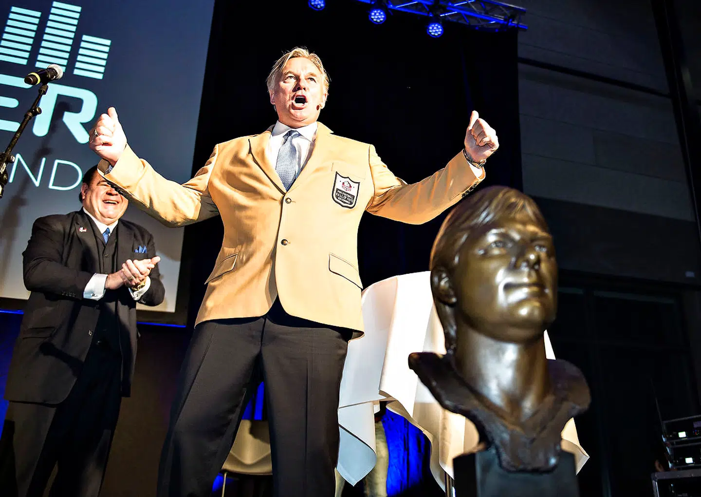 Som medlem af Hall of Fame får man - ud over en bronzebuste - en guldjakke og en ring. Under hyldestshowet i Struer Energi Park genopførte præsidenten for Pro Football Hall of Fame, David Baker, den ceremoni, der normalt finder sted på medlemmets gamle hjemmebane foran et fyldt stadion. Morten Andersen havde dog valgt, at den skulle foregå i Struer, og derfor blev han først iført sin guldjakke på scenen, selv om han var blevet fejret i timevis inden da. Foto: Henning Bagger