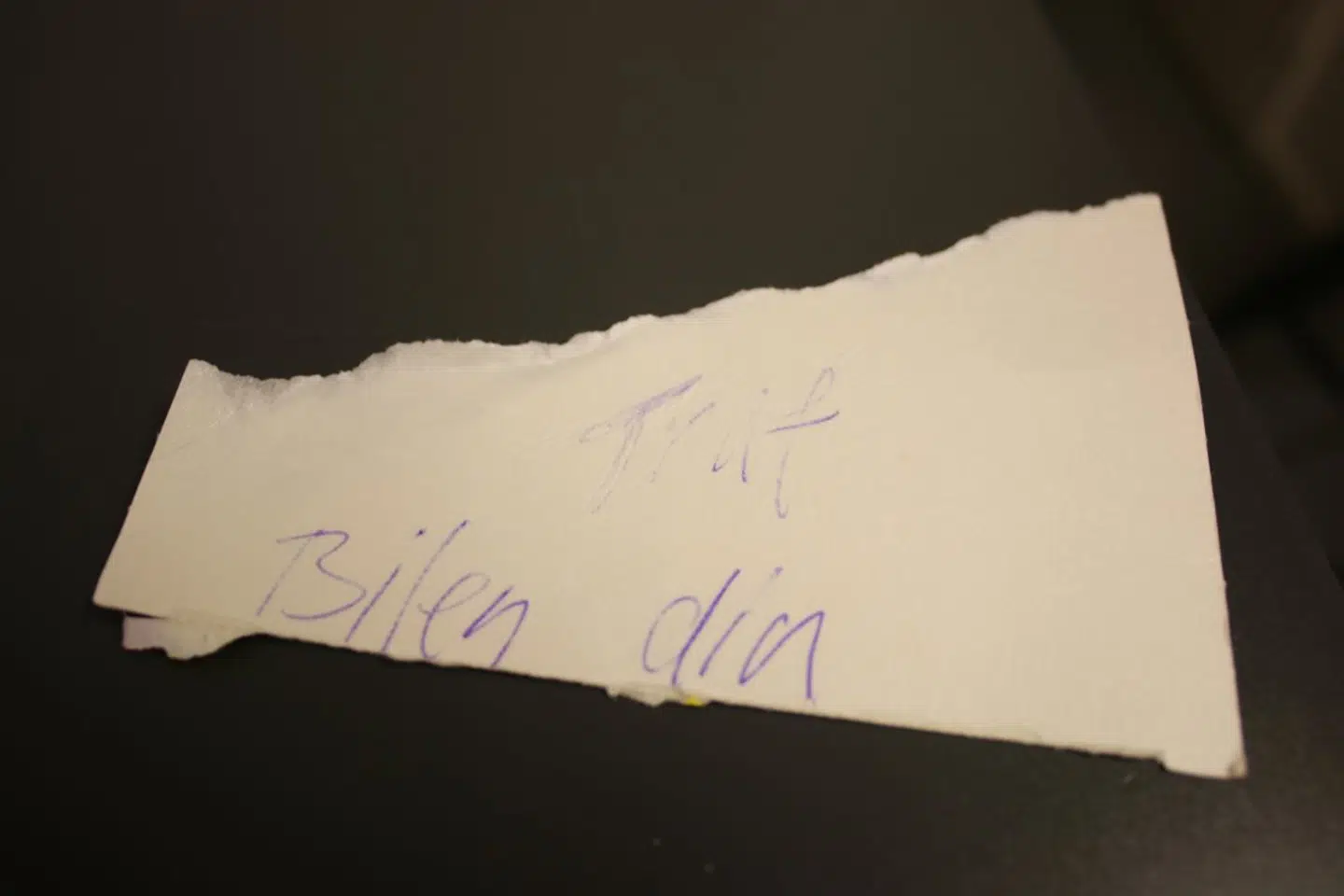 »Traf bilen din,« står der på sedlen, der er skrevet på et stykke pap fra en pakke pålægschokolade fra Galle & Jessen.