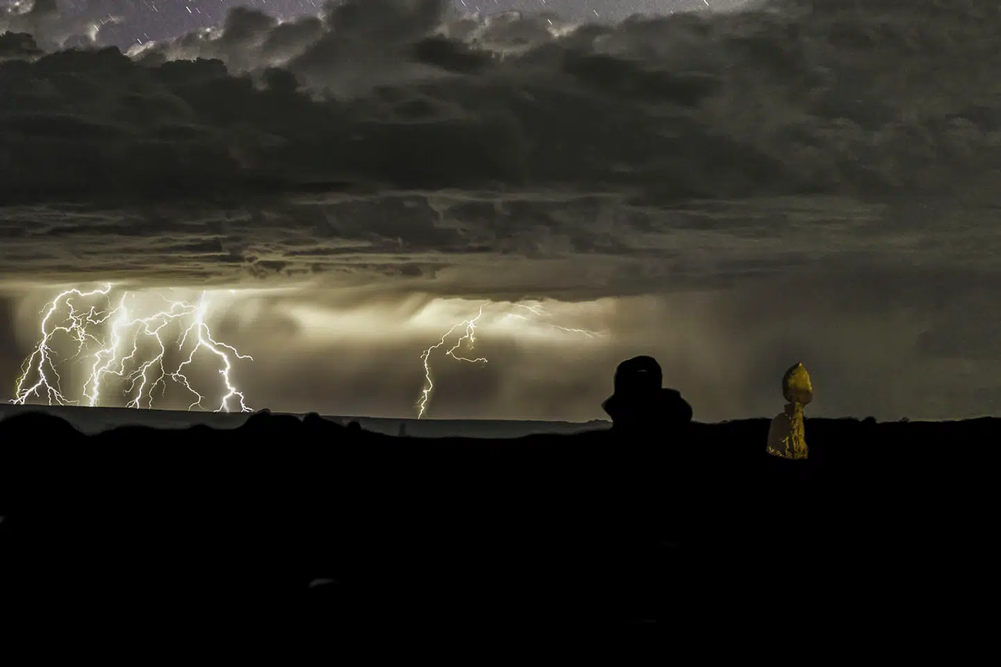 A long exposure of a lightning storm at night over Arches National Park near Moab, Utah. The headlights of a passing car lit up Balanced Rock at right. (Jon G. Fuller / VWPics via AP Images)