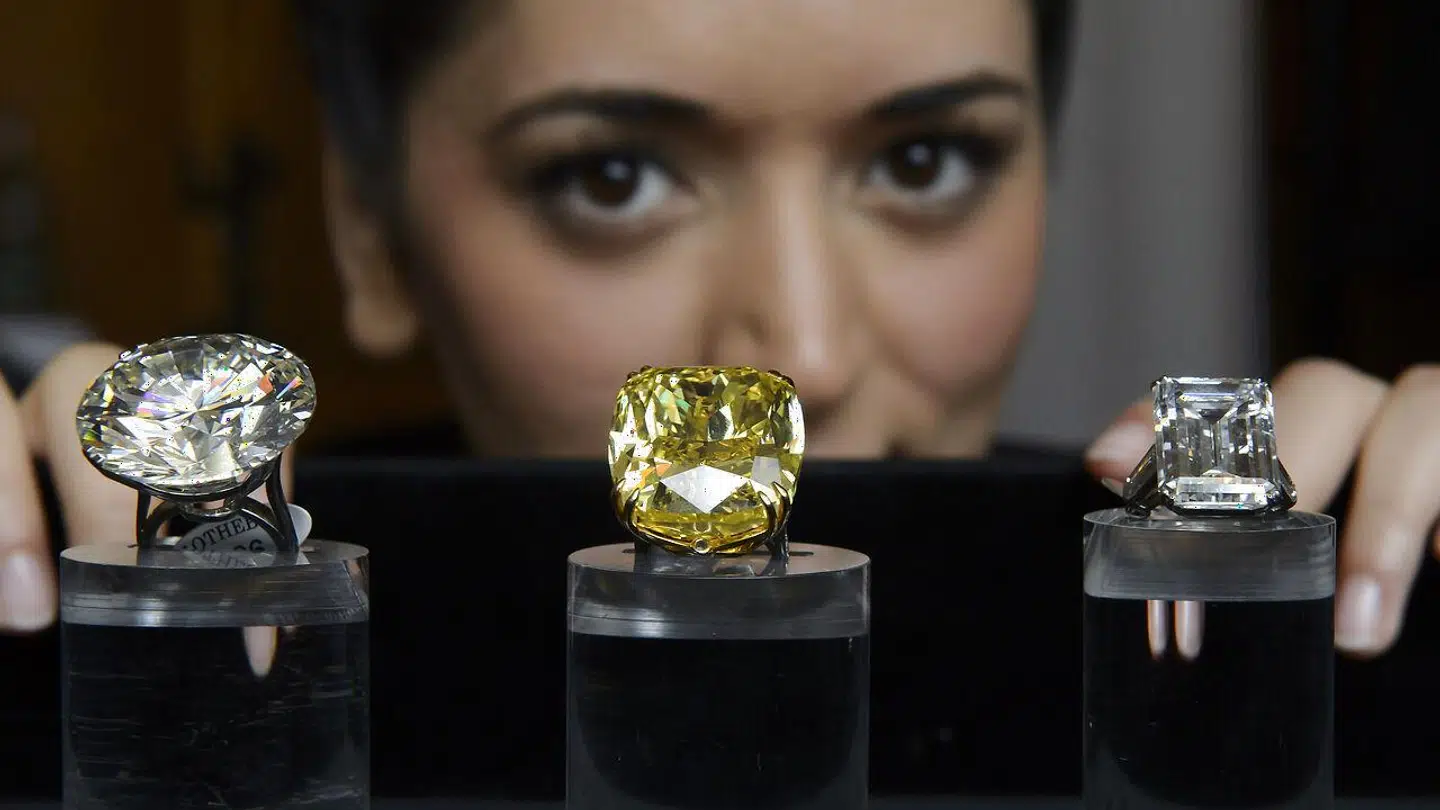 A Sotheby's employee shows three exceptional diamonds during a preview at the Sotheby's, in Geneva, Switzerland, Wednesday, May 7, 2014. Left to right: one of the world's largest known round brilliant-cut diamonds weighing 103.46 carats, which is estimated to sell between 3, 500, 000 to 5, 000, 000 US Dollar, the Graff Vivid Yellow at 100.09 carats, one of the rarest yellow diamonds of its size, which is estimated to sell between 15, 000, 000 to 25, 000, 000 US Dollar and the Victory Diamond, a 31.34 carat diamond named to commemorate the allied victory in World War II, which is estimated to sell between 5, 000, 000 to 8, 000, 000 US Dollar at the auction in Geneva on May 13, 2014. (KEYSTONE/Martial Trezzini)