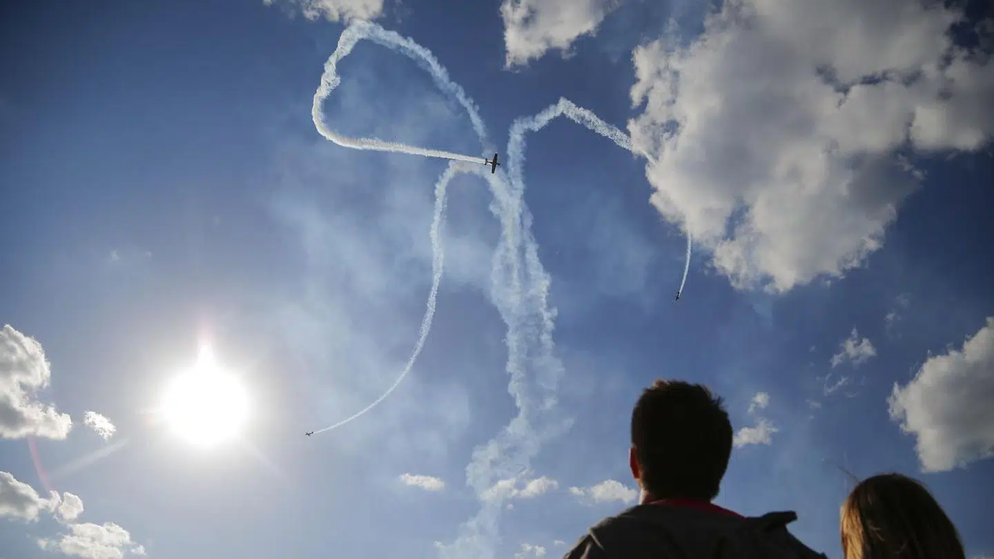 Spectators watch as planes performs during the Sky, Theory and Practice festival at airfield "Black" in Balashikha, outside in Moscow, Russia, Saturday, May 22, 2021. (AP Photo/Alexander Zemlianichenko Jr)
