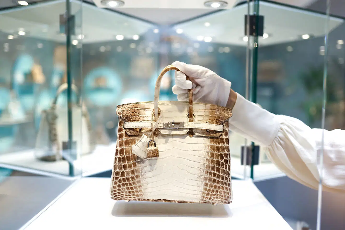 FILE PHOTO: Rachel Koffsky, International Senior Specialist at Christie's Handbags & Accessories, poses with a piece titled "A rare, matte white himalaya niloticus crocodile Birkin 25 with palladium hardware, Hermes, 2013" which is on display as part of "Handbags Online: The London Edit" at Christie's in London, Britain, November 18, 2021. REUTERS/Tom Nicholson/File Photo