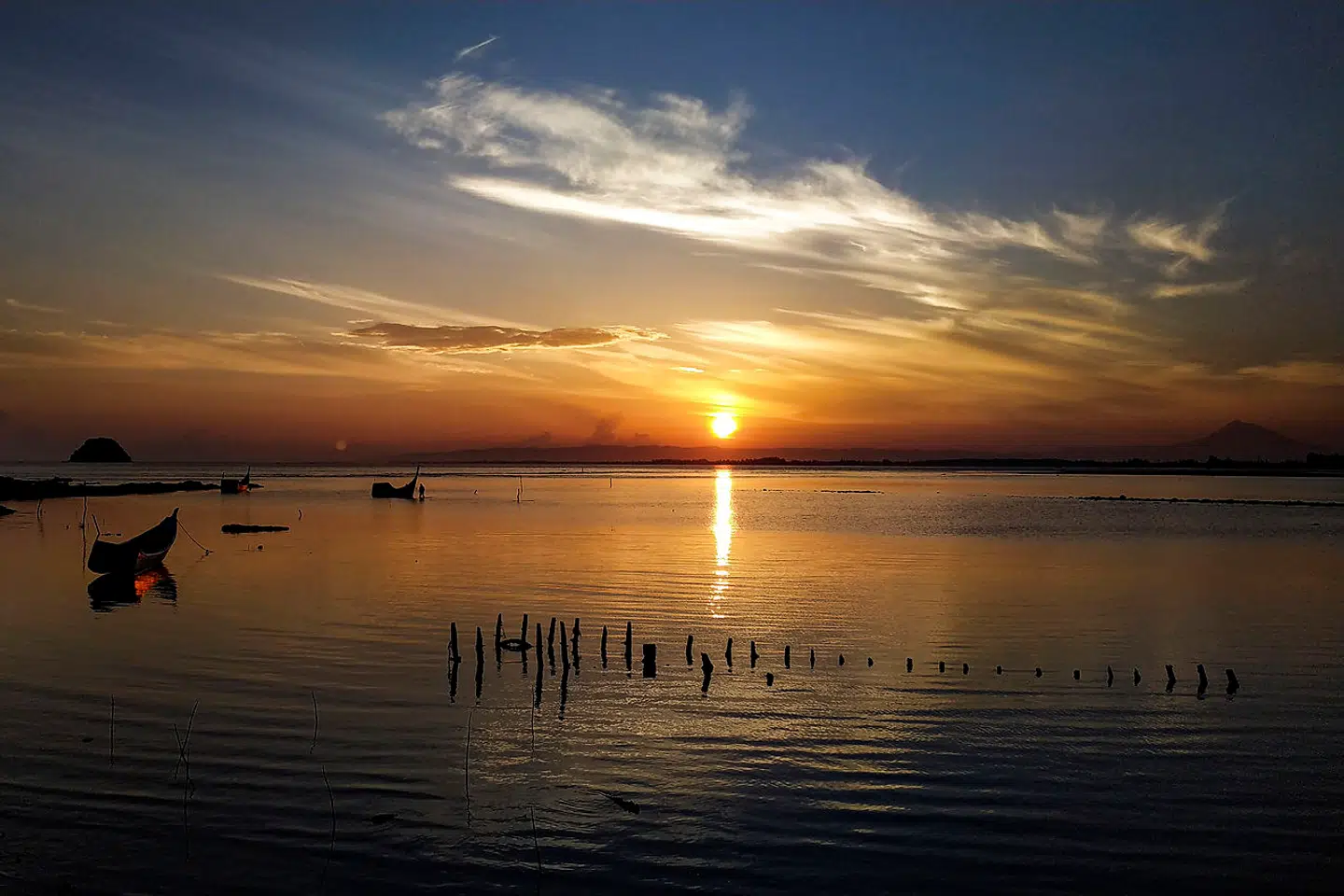A fishing boat is moored at a beach during sunrise in Pekan Bada, Indonesia's Aceh province on April 10, 2021. CHAIDEER MAHYUDDIN / AFP