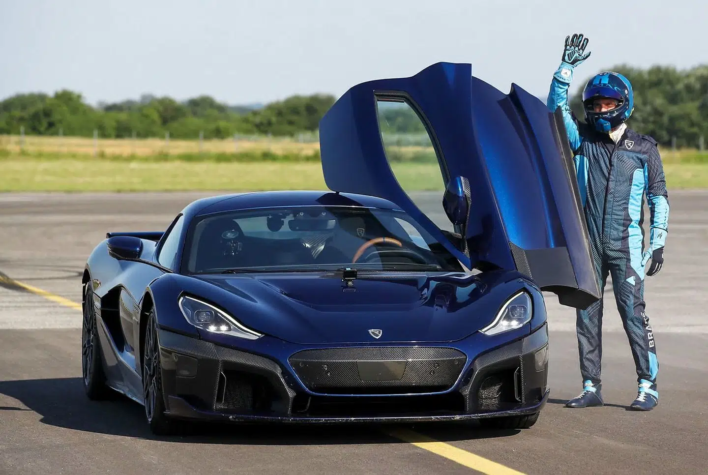 Driver Miroslav Zrncevic gestures next to Croatian electric supercar Rimac Nevera during the event "Fly over Rimac Nevera" at local airport in town Varazdin, in northern Coratia, on June 11, 2022. (Photo by Damir Sencar / AFP)