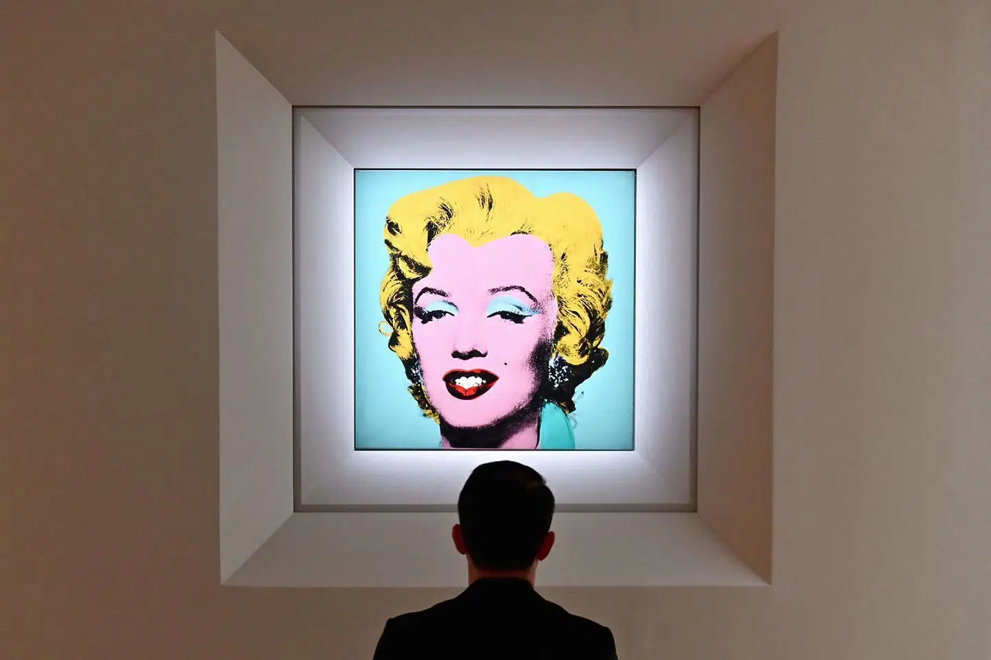 (FILES) In this file photo taken on April 29, 2022 a man looks at Andy Warhol's 'Shot Sage Blue Marilyn' during Christie's 20th and 21st Century Art press preview at Christie's New York in New York City. - An iconic portrait of Marilyn Monroe by American pop art visionary Andy Warhol went under the hammer for a record $195 million on May 9, 2022 at Christie's, becoming the most expensive 20th century artwork ever sold at public auction. "Shot Sage Blue Marilyn, " produced in 1964 two years after the death of the glamourous Hollywood star, sold for exactly $195.04 million, including fees, in just four minutes in a crowded room at Christie's headquarters in Manhattan. (Photo by Angela Weiss / AFP)