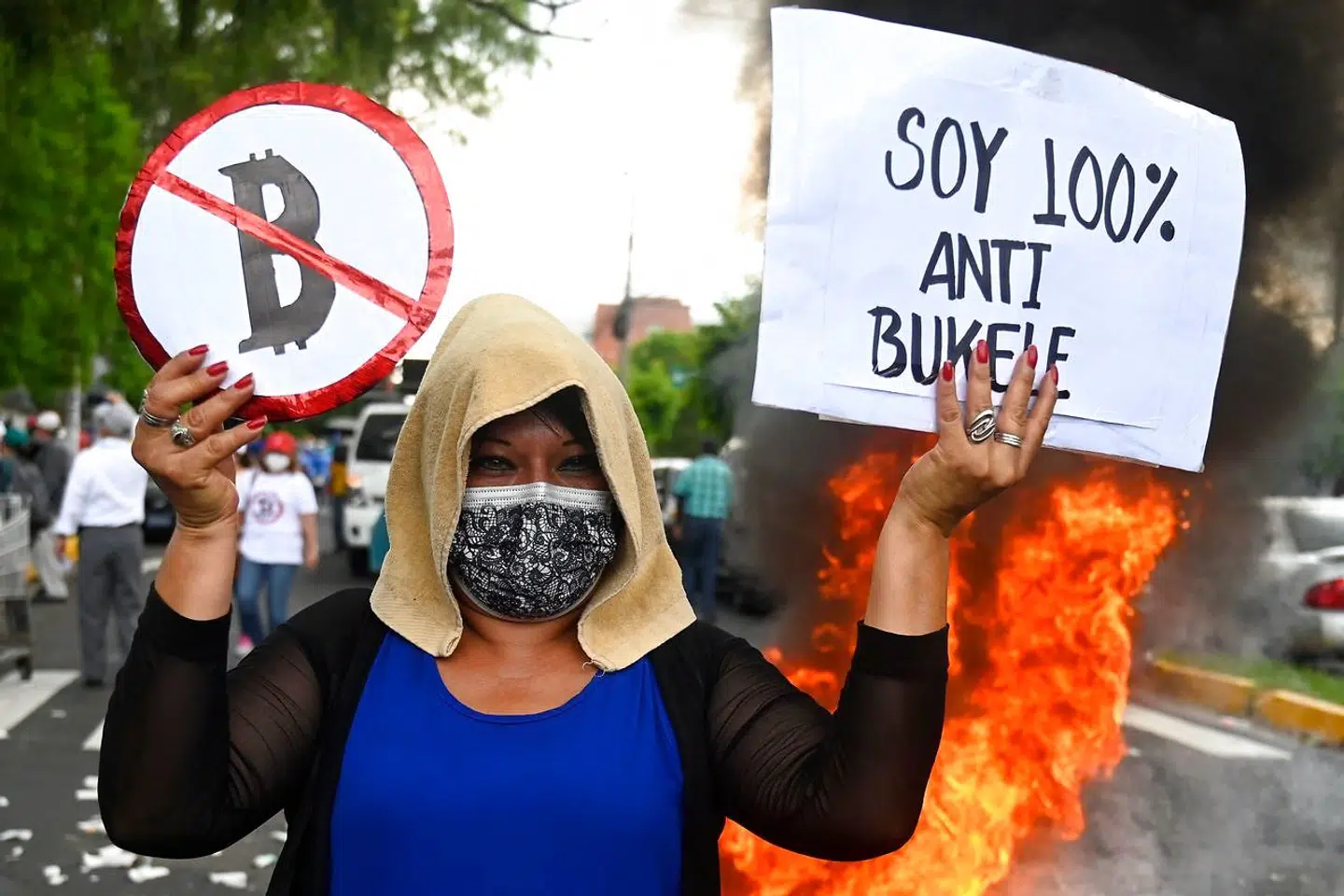 TOPSHOT - A woman protests against the circulation of Bitcoin in San Salvador on September 7, 2021. - El Salvador on Tuesday becomes the first country in the world to accept bitcoin as legal tender, despite widespread domestic skepticism and international warnings of risks for consumers. (Photo by MARVIN RECINOS / AFP)
