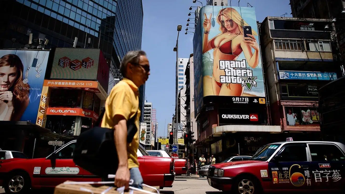 Grand Theft Auto bliver udviklet og udgivet af TakeTwo Interactives underselskab, Rockstar Games. Her går en fodgænger forbi en reklame for 'Grand Theft Auto'-computerspillet.