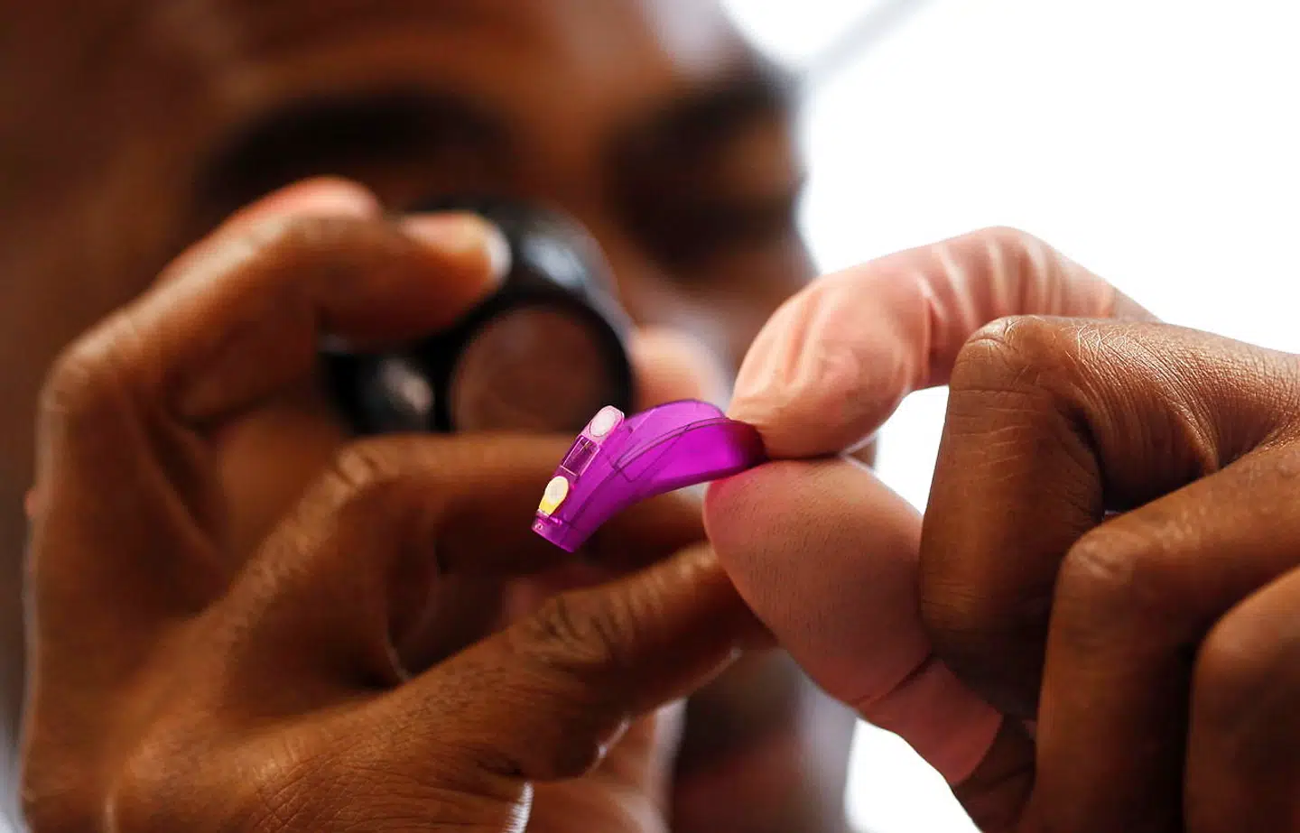 Her er en ansat ved at undersøge et høreapperat fra Sonova.