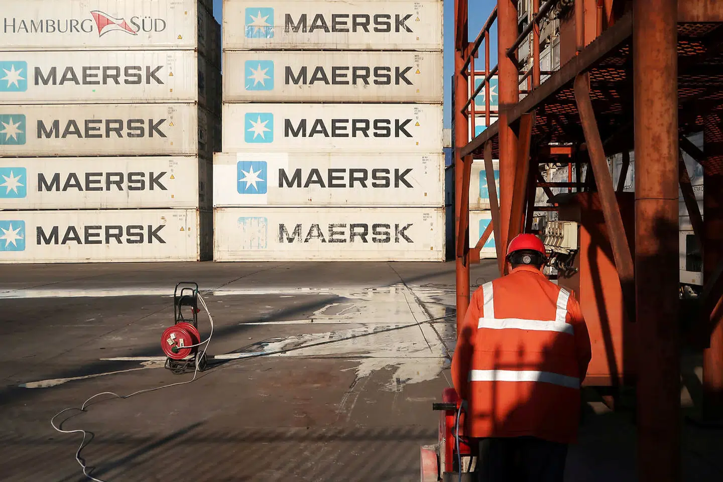 A worker is seen next to Maersk shipping containers at a logistics center near Tianjin port, in Tianjin, China December 12, 2019.