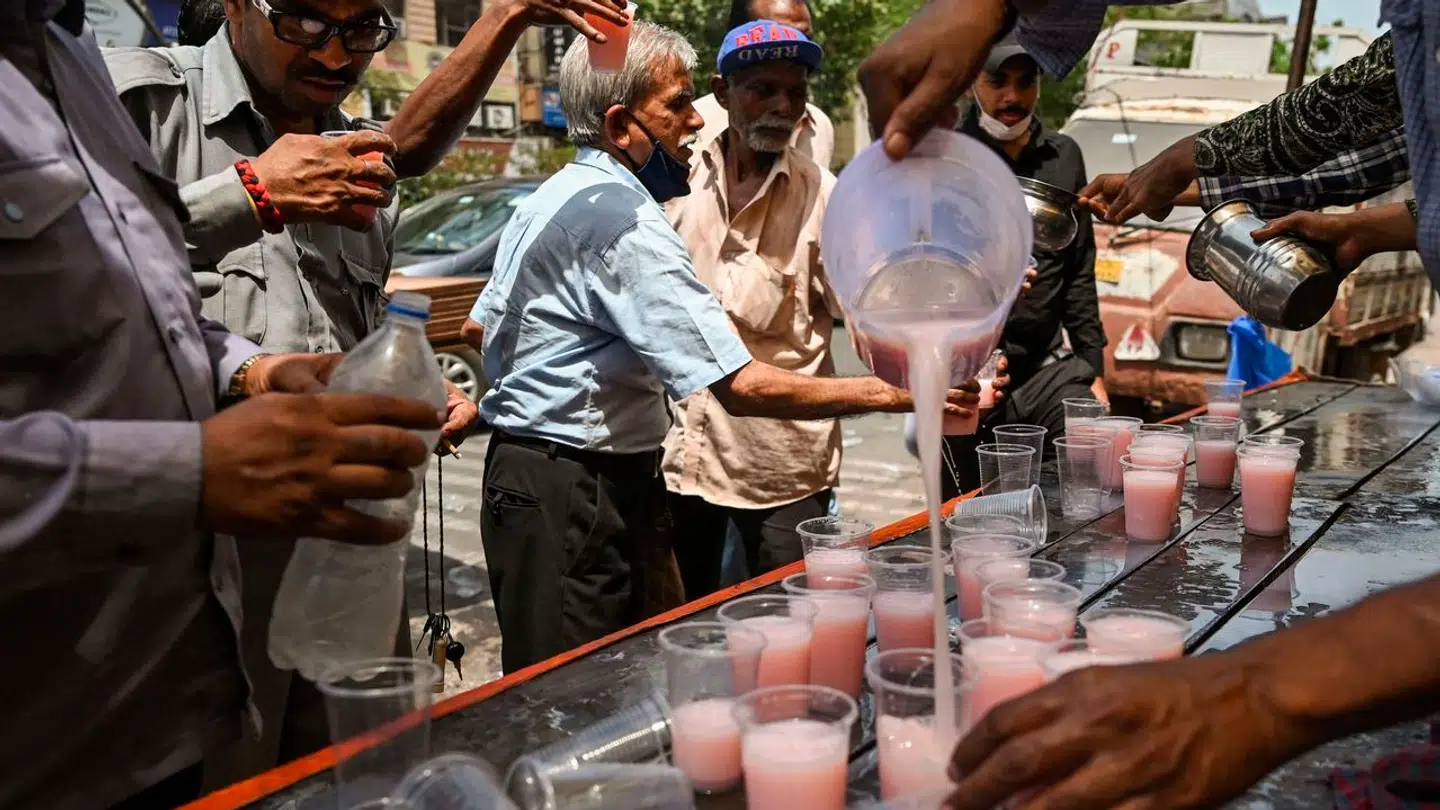 Frivillige uddeler gratis væske til folk under en hedebølge i den indiske storby New Delhi den 23. maj i år.