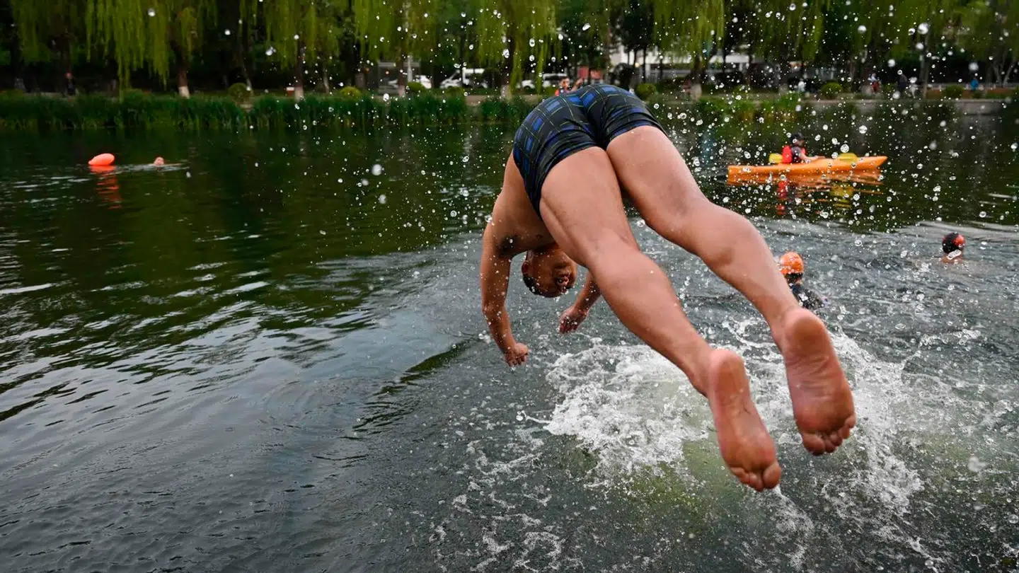 I Beijing brugte indbyggerne blandt andet byens kanaler til at køle sig ned. Billedet er fra fredag den 23. juni.