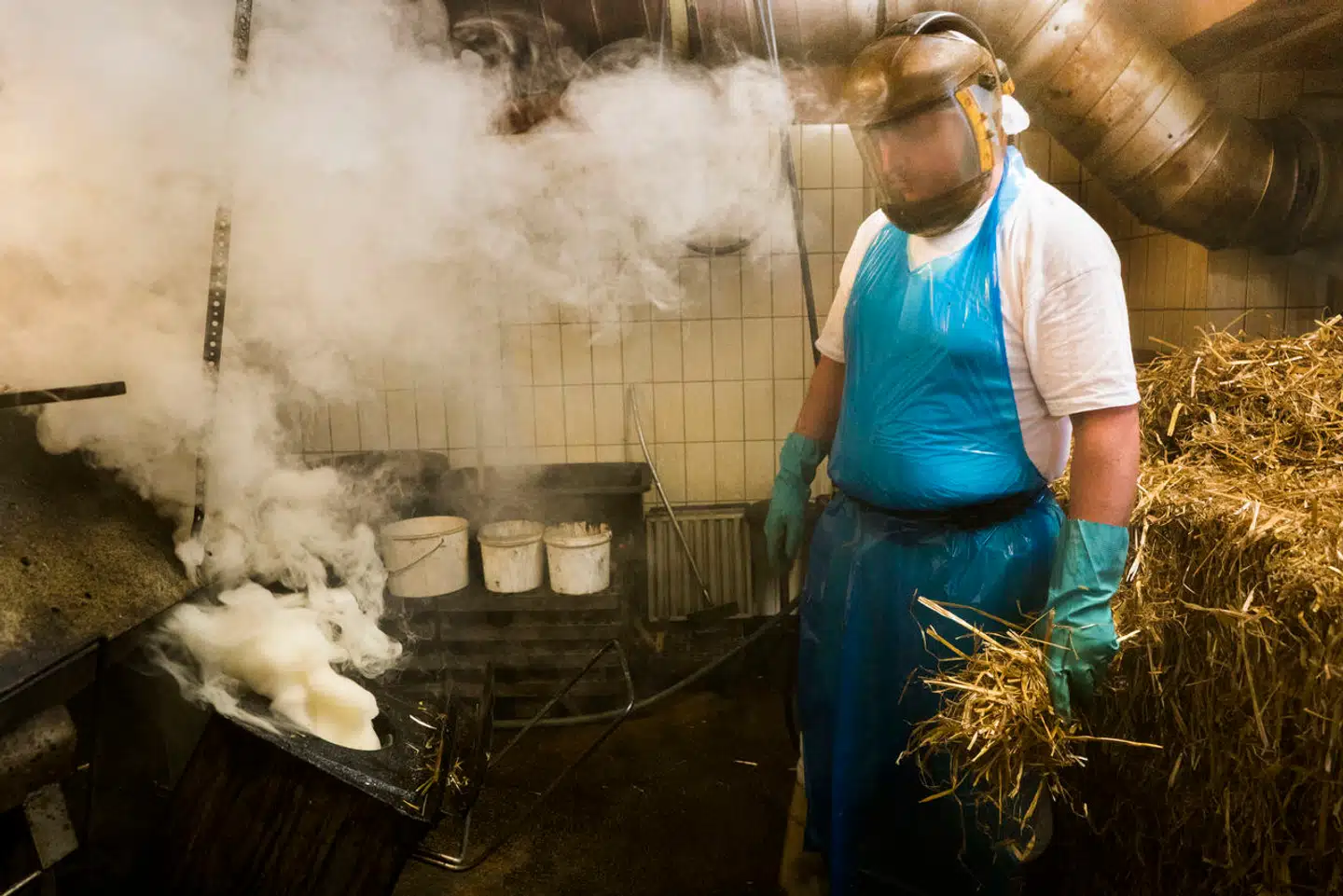 Løgismose er kendt for innovativ fødevareproduktion. Her et billede fra virksomhedens mejeri, hvor en ansat er i færd med rygning af rygeost.