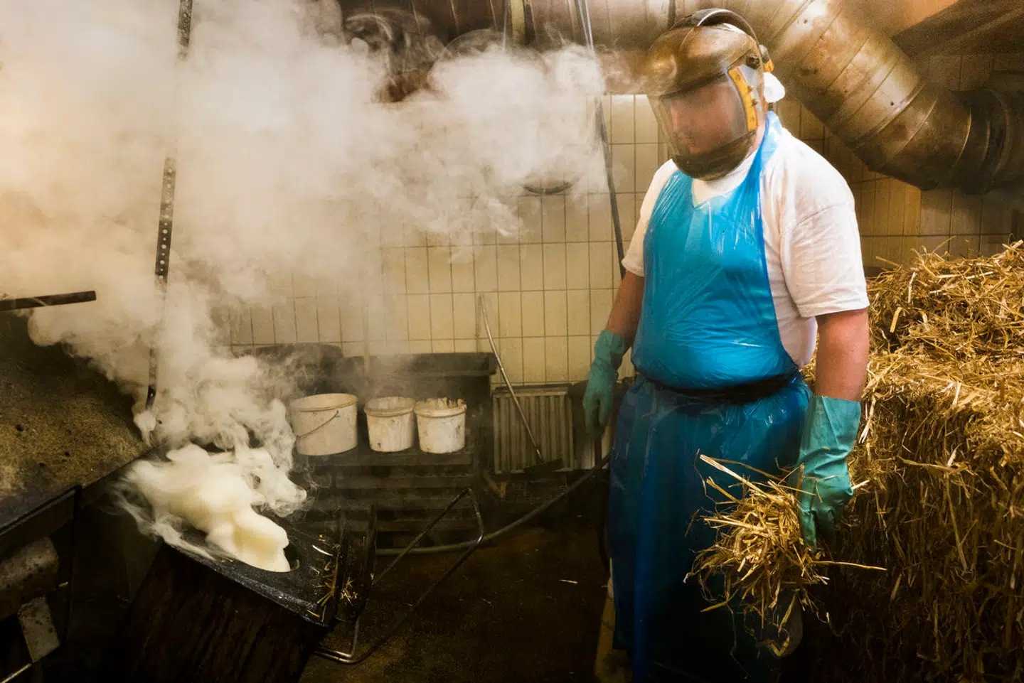 Løgismose er kendt for innovativ fødevareproduktion. Her et billede fra virksomhedens mejeri, hvor en ansat er i færd med rygning af rygeost.