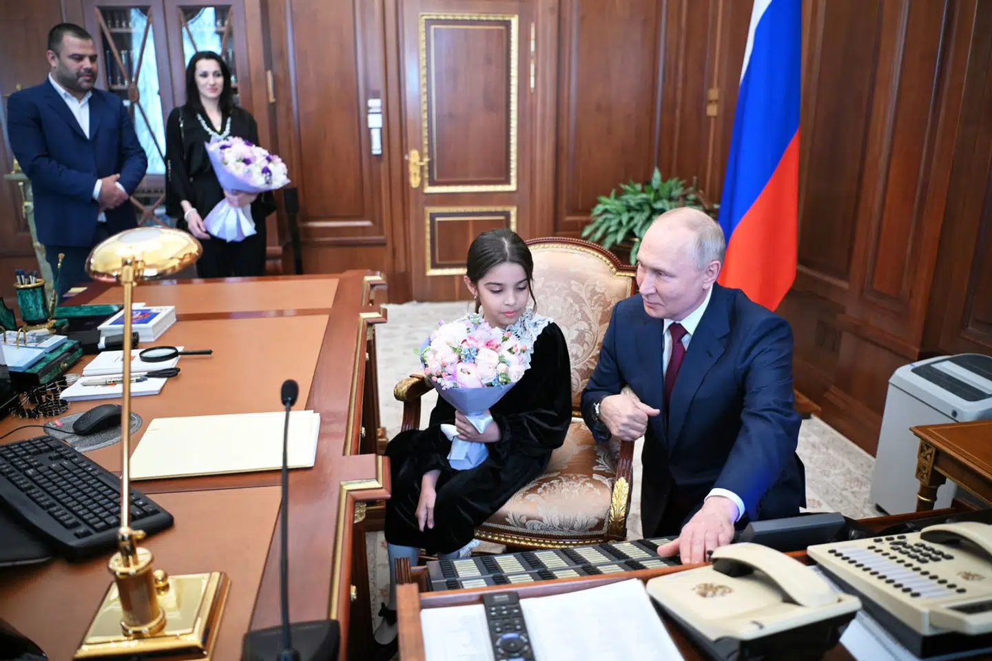 Raisat Akipova blev ifølge Kreml vist rundt på Vladimir Putins kontor under mødet. I baggrunden står hendes forældre.