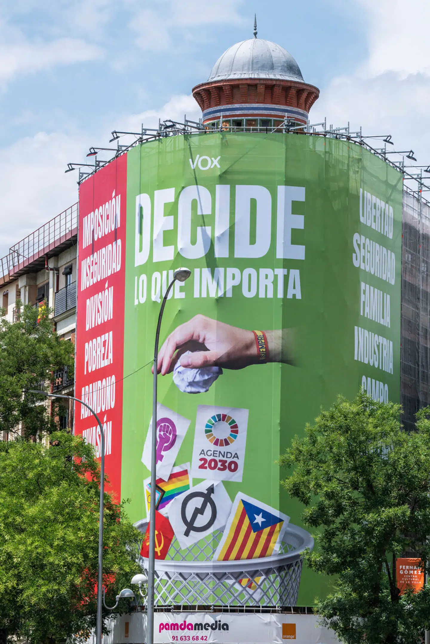 På et enormt valgbanner smider Vox alle de flag, det højrenationale parti ikke kan lide – heriblandt et regnbuefarvet, i skraldespanden.