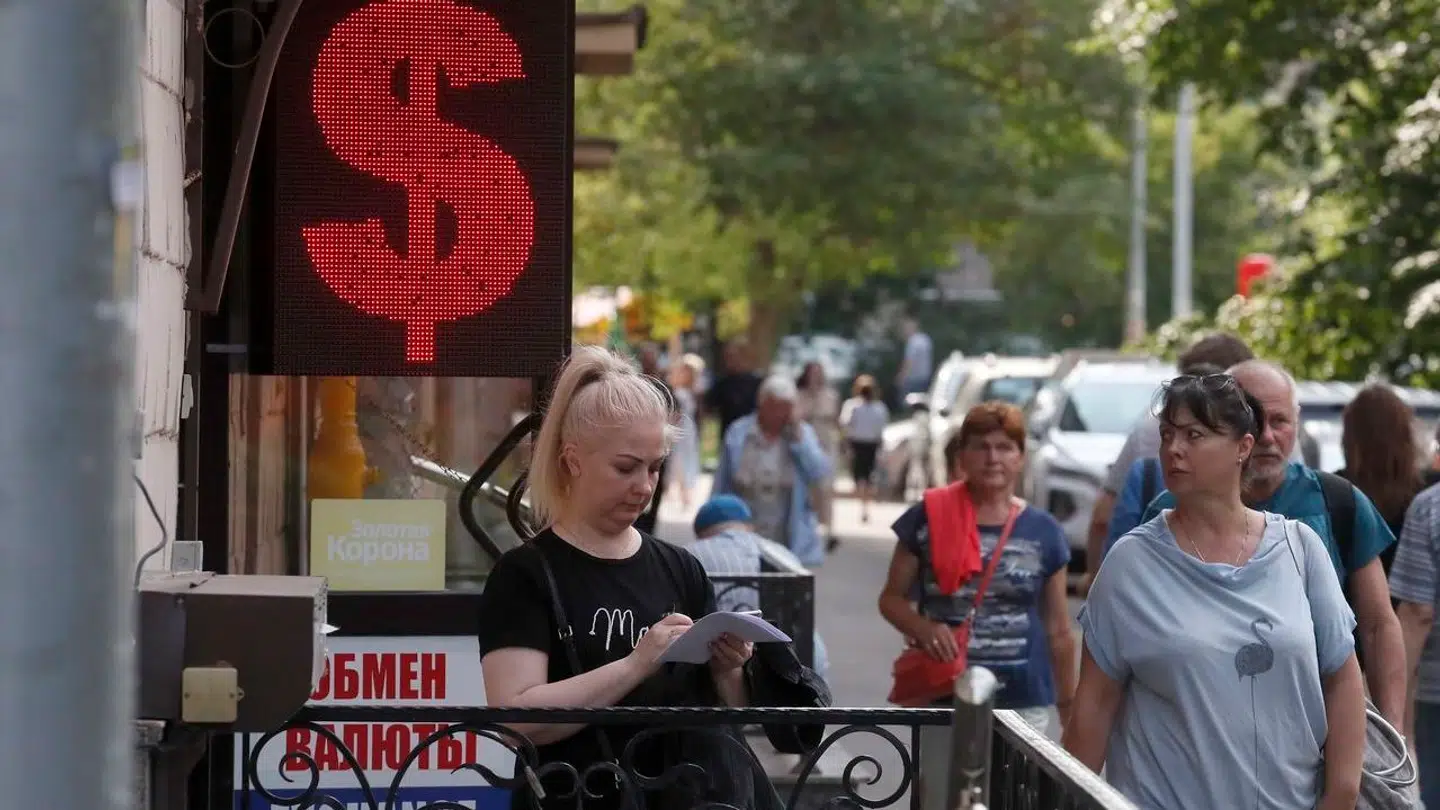 De russere, der den 6. juli besøgte dette vekselkontor i Sankt Petersborg, skulle have voldsomt mange rubler op for at erhverve sig amerikanske dollars. EPA/ANATOLY MALTSEV