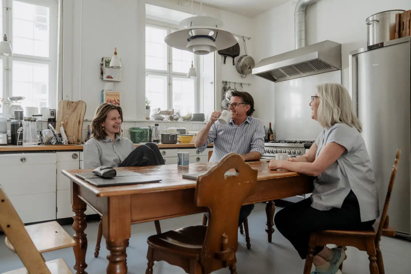 Historieprofessor og provst på Regensen Stuart Ward, hans kone Lill Baad (til højre) og deres datter Emilie (til venstre) hygger sig i provsteboligens køkken. Den dag de flyttede ind for 13 år siden, havde beboerne på Regensen som en practical joke placeret en flagstang i boligen, som blandt andet blokerede køkkenet.