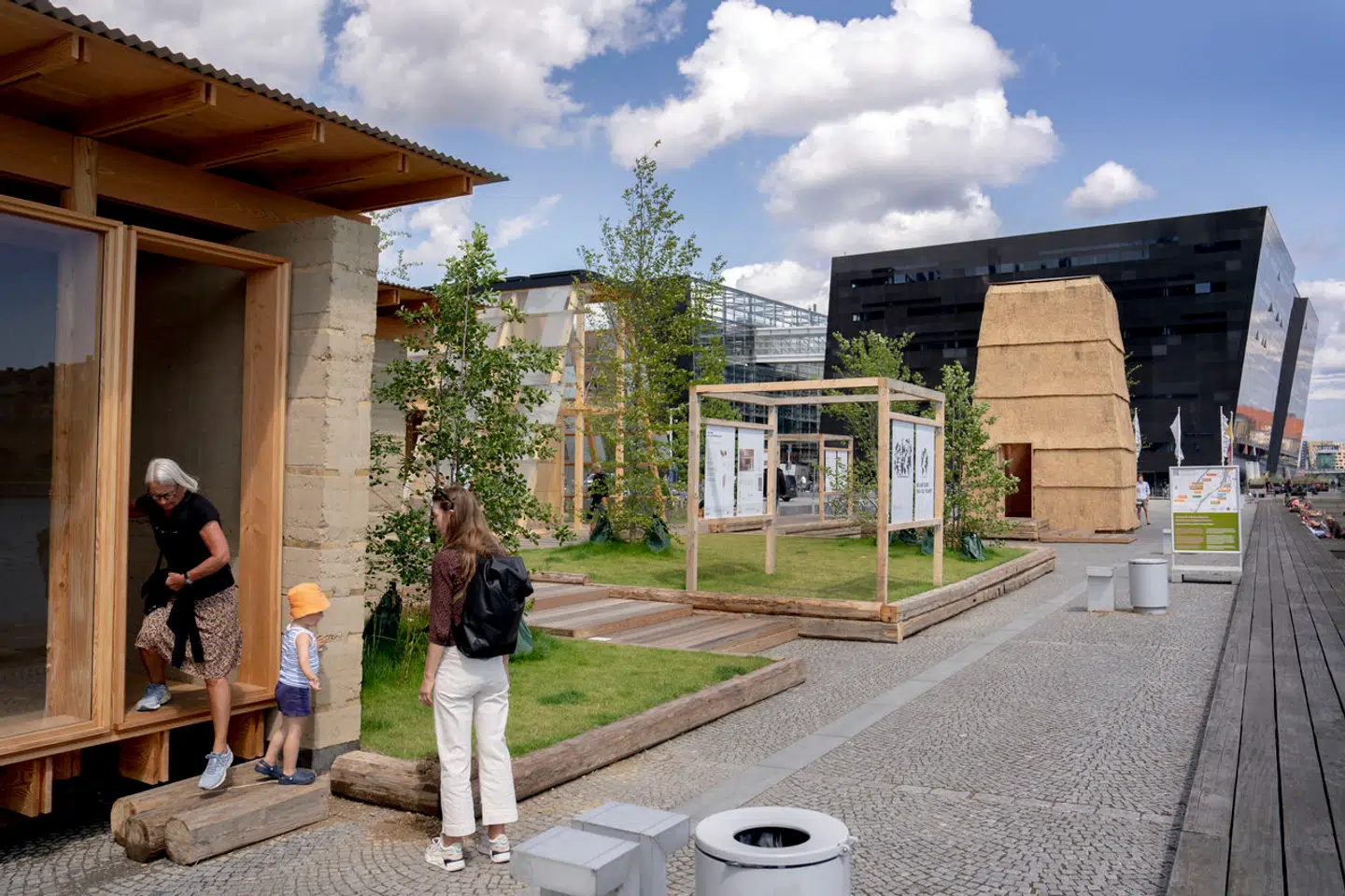 I forgrunden ReVærks lerhytte, i midten tegnestuen LOKAL og Aaen Engineerings træhus og længst væk Rønnow, Leth og Gori og CINARKs husi monoblokke og tækkerør. Tilsammen er de tre pavilloner både interessante og berigende for Søren Kierkegaards Plads.