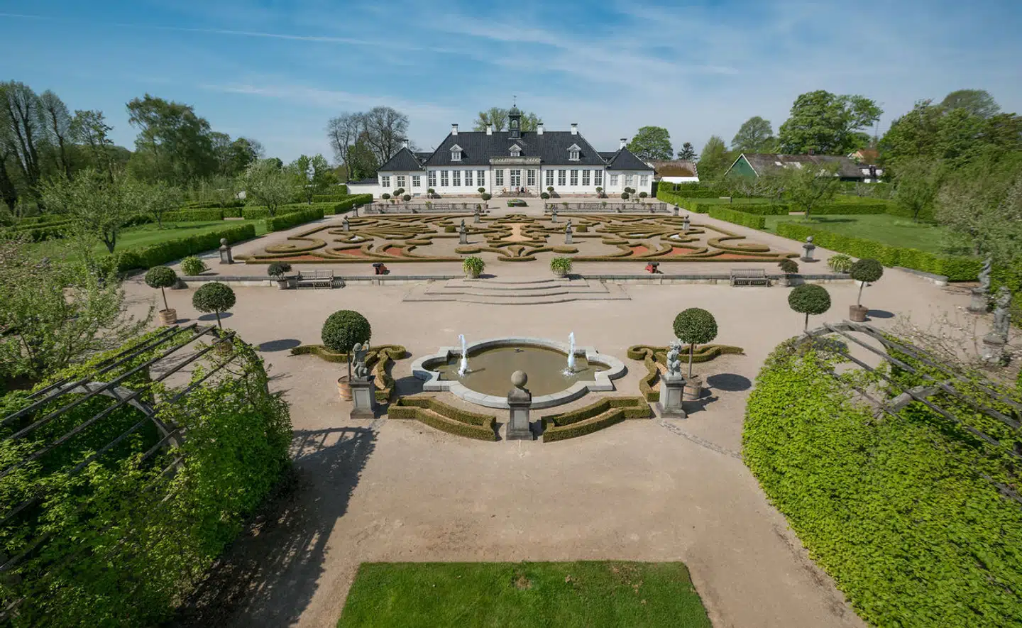 Gl. Holtegaard blev bygget i 1756‑57, og var oprindeligt Lauritz de Thurahs landsted. Lauritz de Thurah står også bag haven, der blev anlagt i 1756 som en franskinspireret symmetrisk barokhave. Buegange danner midtvejs en rund plads, og nærmest hovedbygningen er buksbom- og blomsterparterre og vandkunst. En del lindetræer og sneglebakken Mariehøj stammer fra Lauritz de Thurahs tid, skriver Lex.dk.