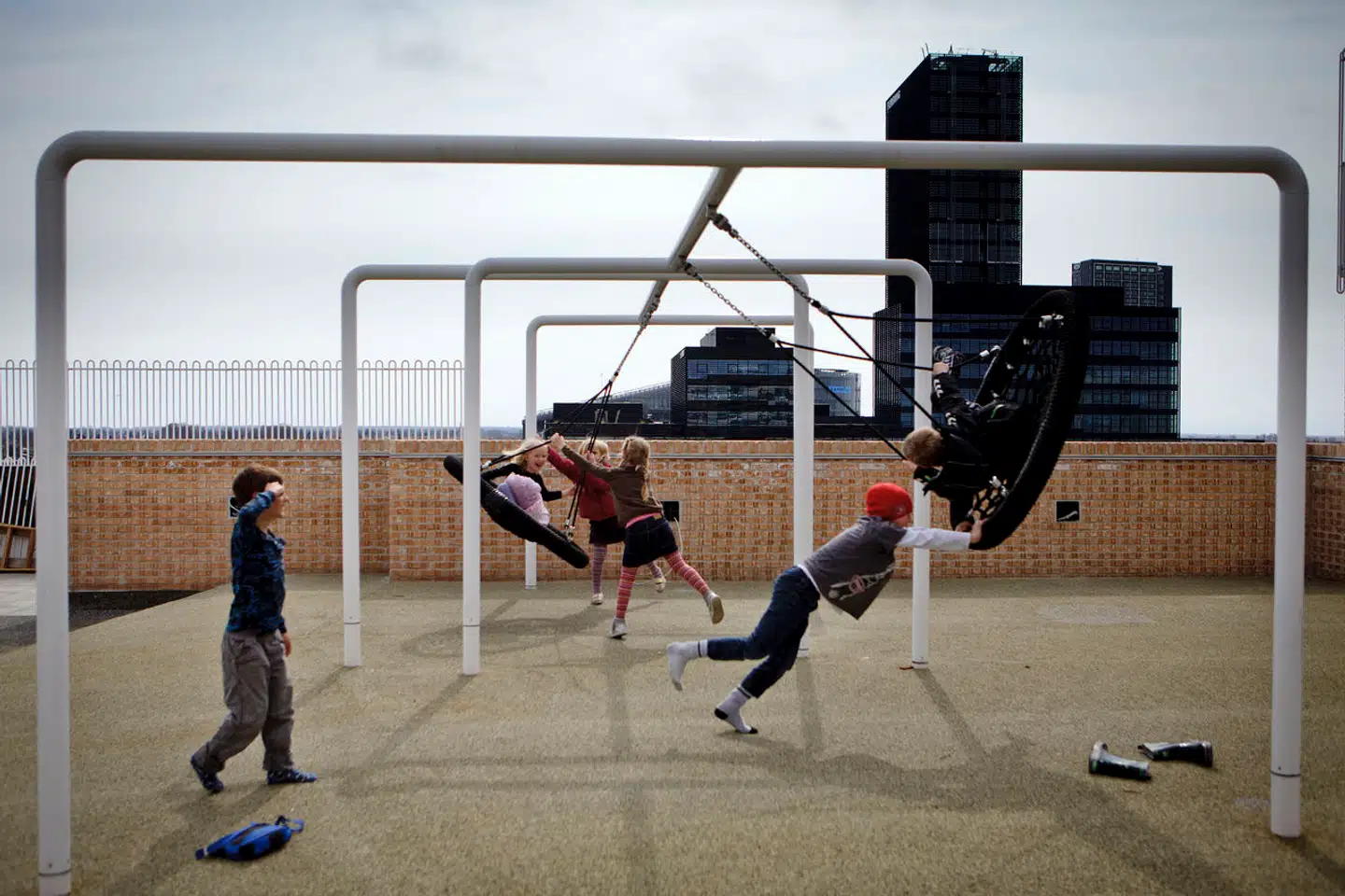 En lang række taglegepladser er skudt op i København den seneste årrække, men flere af dem oplever problemer med blandt andet vejrforhold og vandindtrængning. På Ørestad Skole har man oplevet, at nogle elever har smidt ting ud over kanten. Børnene på dette billede har intet med de episoder at gøre. (arkivbillede)