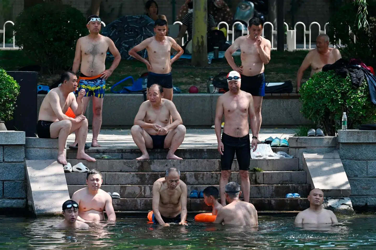 Torsdag nåede temperaturen i Beijing op over 41 grader. Det er den højeste temperatur, der nogensinde er målt i Beijing i juni. Her ses mænd køle af i en kanal i den kinesiske hovedstad.