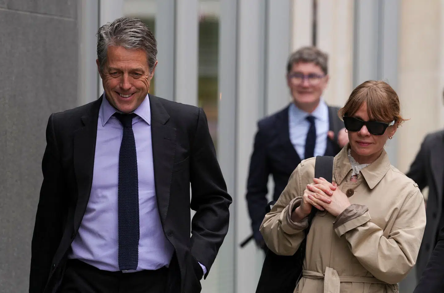 Hugh Grant er tilfreds med, at hans sag nu bliver afgjort af en dommer. Her er han fotograferet ude foran retten i London.