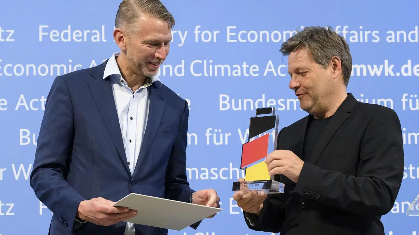 Så er der grønt lys til et stort milliardtilskud. Den tyske økonomi- og klimaminister Robert Habeck (th.) overrækker et symbolsk batteri i de tyske flagfarver til Peter Carlsson, som er topchef for den svenske elbatterivirksomhed Northvolt, som bevis på, at byggeriet af en ny fabrik kan gå i gang.