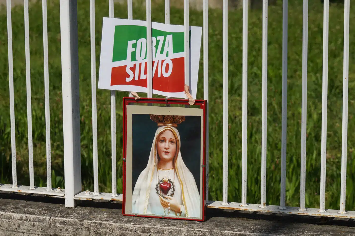 Berlusconi-fans har opstillet et jomfrubillede side om side med Forza Italias partilogo uden for San Raffaele-hospitalet, hvor den tidligere premierminister har været indlagt siden begyndelsen af april.
