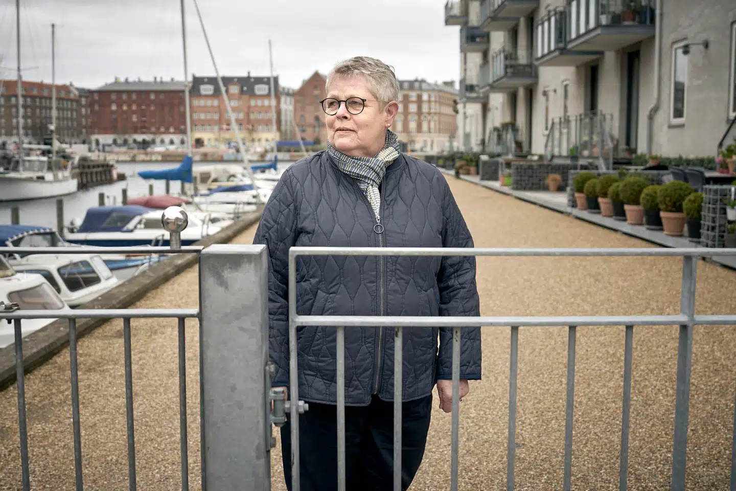 Kirsten Høgh Fogt foran det hegn på Christianshavn, der blev opsat i 2014 for at give beboerne fred for uvelkomne gæster. Nu har Østre Landsret besluttet, at det skal væk.