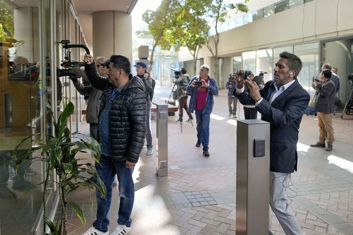 Journalister forsøger at få et billede af Alejandro Toledo, efter at han har overgivet sig til amerikanske myndigheder i retsbygningen Robert F. Peckham Federal Building i San José i Californien fredag. Tony Avelar/Ritzau Scanpix