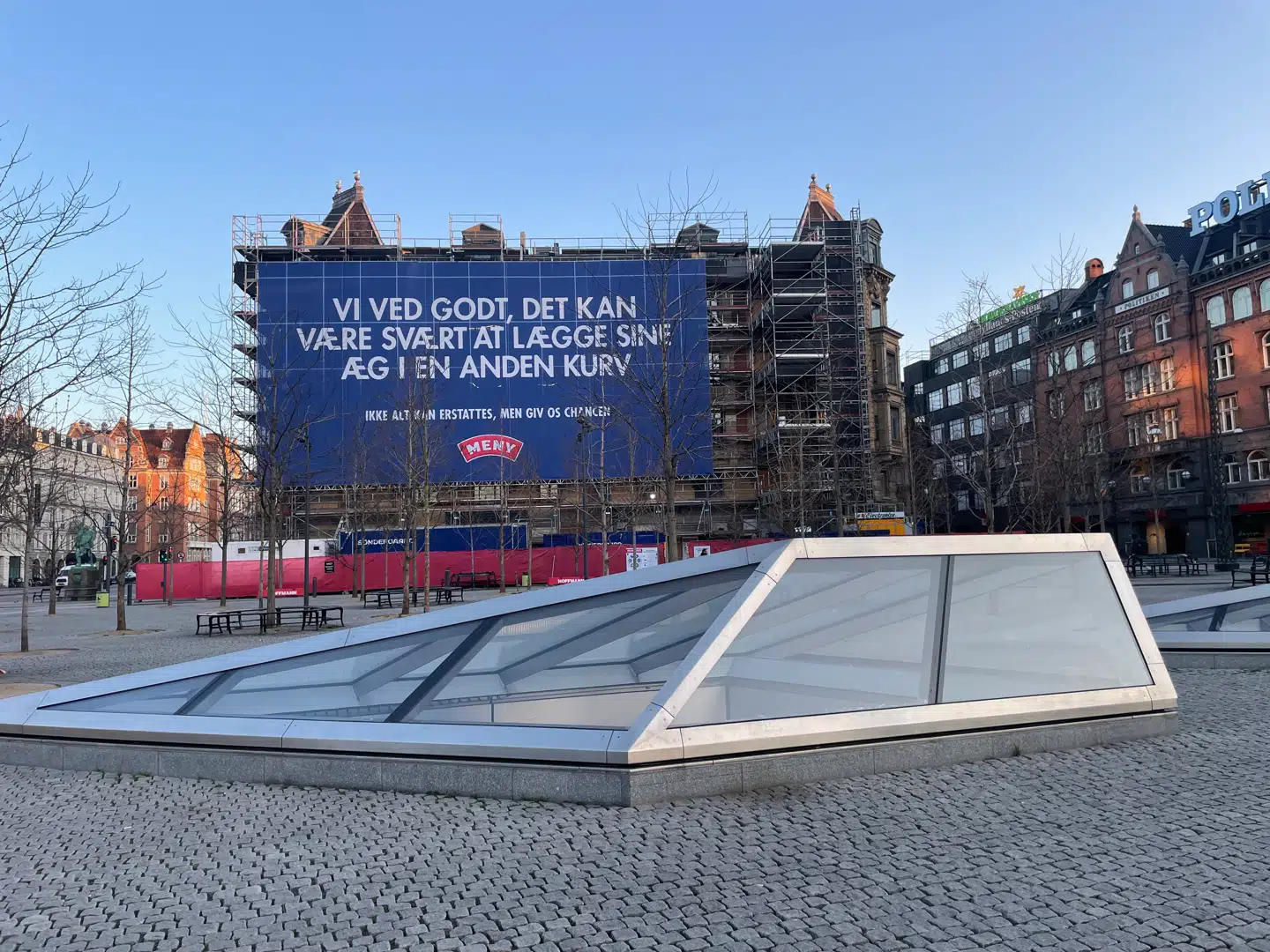 Rådhuspladsen i København er onsdag morgen prydet af et stort banner, hvor Meny går direkte efter Irmas kunder.
