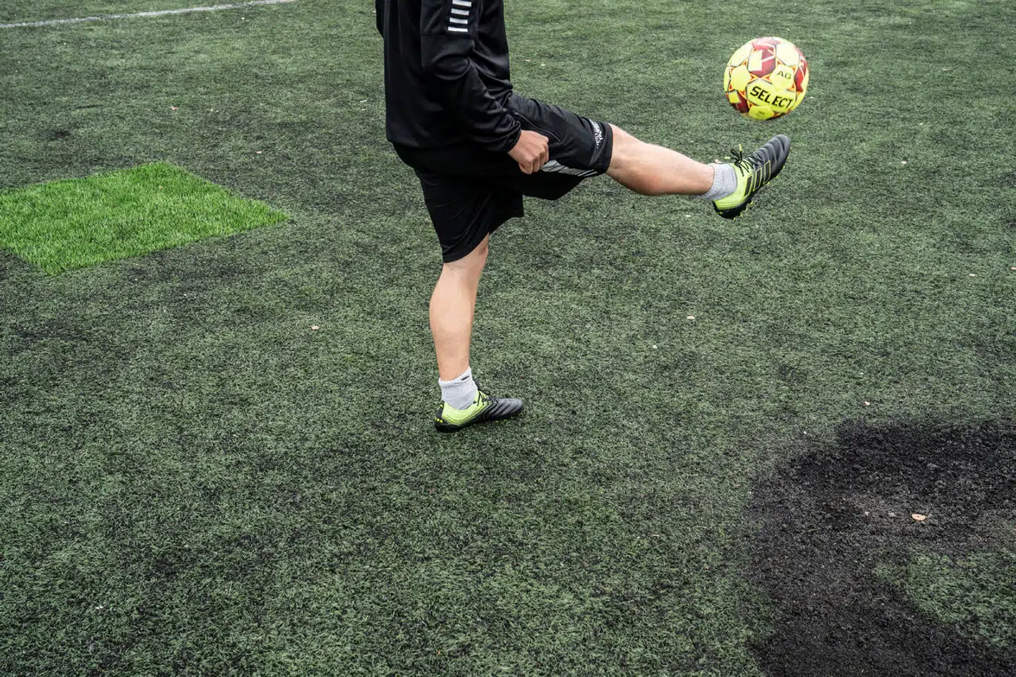 Afbrændte og lappede pletter på kunstgræsbanen på Bavnehøj Idrætsanlæg lige ved siden af Vestre Fængsel.