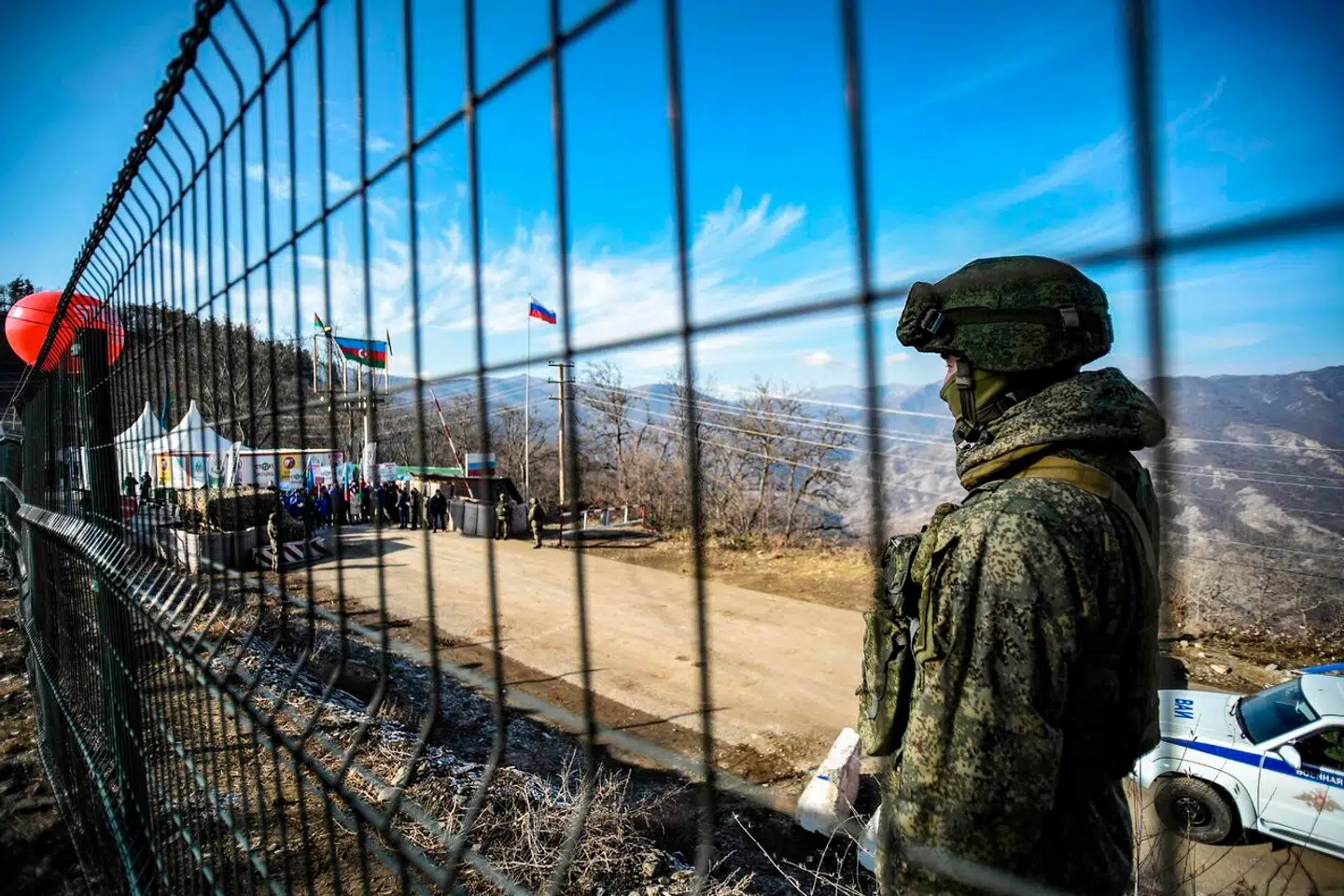 »Demonstranter« blokerer for al civil og kommerciel trafik til Nagorno-Karabakh, så omkring 120.000 etnisk armenske indbyggere ikke har adgang til essentielle varer og tjenester, herunder livsvigtig medicin og sundhedspleje, skriver Anders Fogh Rasmussen. Her bevogter en russisk soldat Latjin-korridoren, mens demonstranterne blokerer vejen i baggrunden.