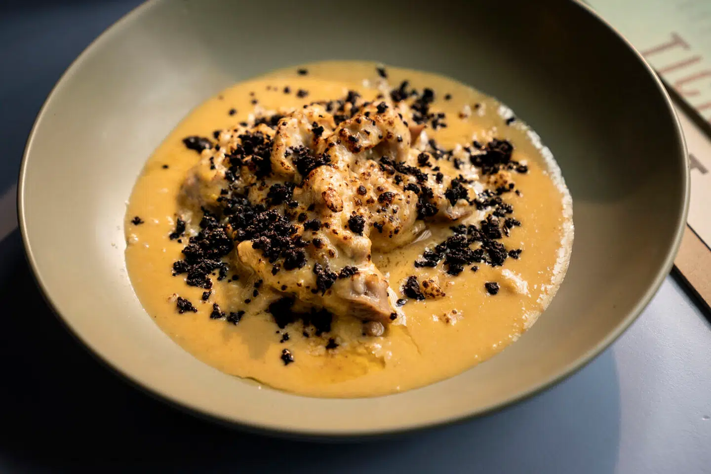 Grillede bidder af kyllingebryst i en sauce på parmesan, fløde og aji amarillo-chilli.