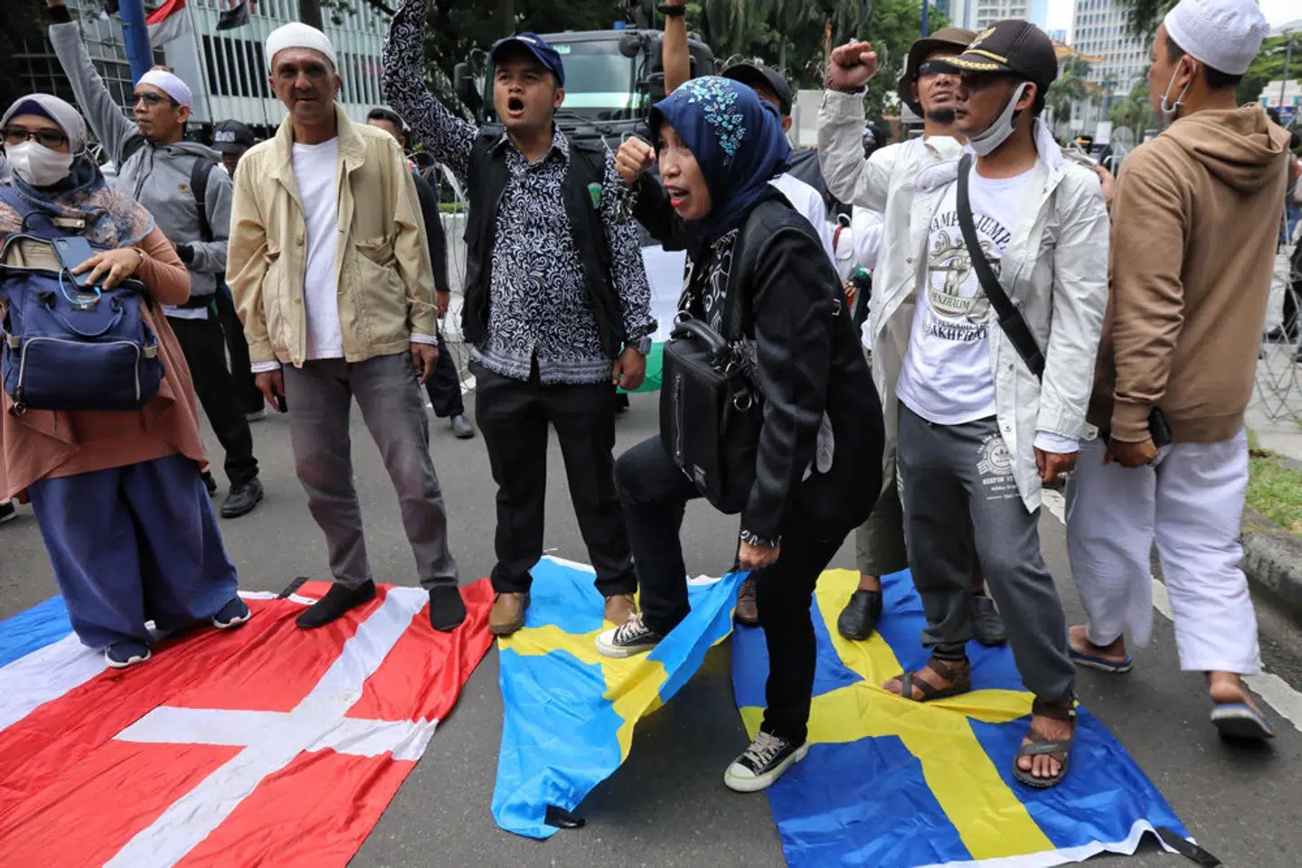 Demonstranter træder på det hollandske, danske og svenske flag uden for den svenske ambassade i Indonesiens hovedstad, Jakarta, mandag den 30. januar. - Foto: Azwar Ipank/Ritzau Scanpix