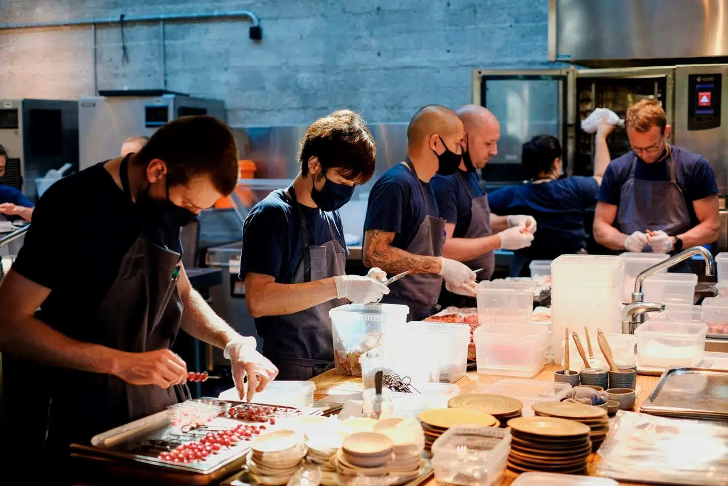 »Forbrugerne skal også være indstillet på at betale mere for at tage på restaurant. Bedre lønninger koster penge, og det må afspejle sig i prisen,« skriver Caroline Schneider Lambert. Her ses travle medarbejdere på Noma.