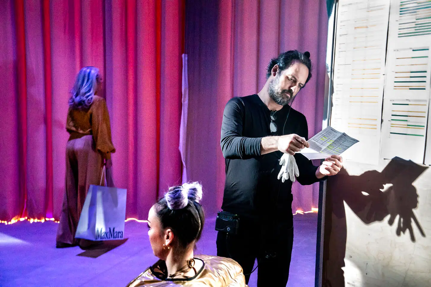 Der er for mørkt på scenen til, at man kan læse. Derfor må man gå om bagved.