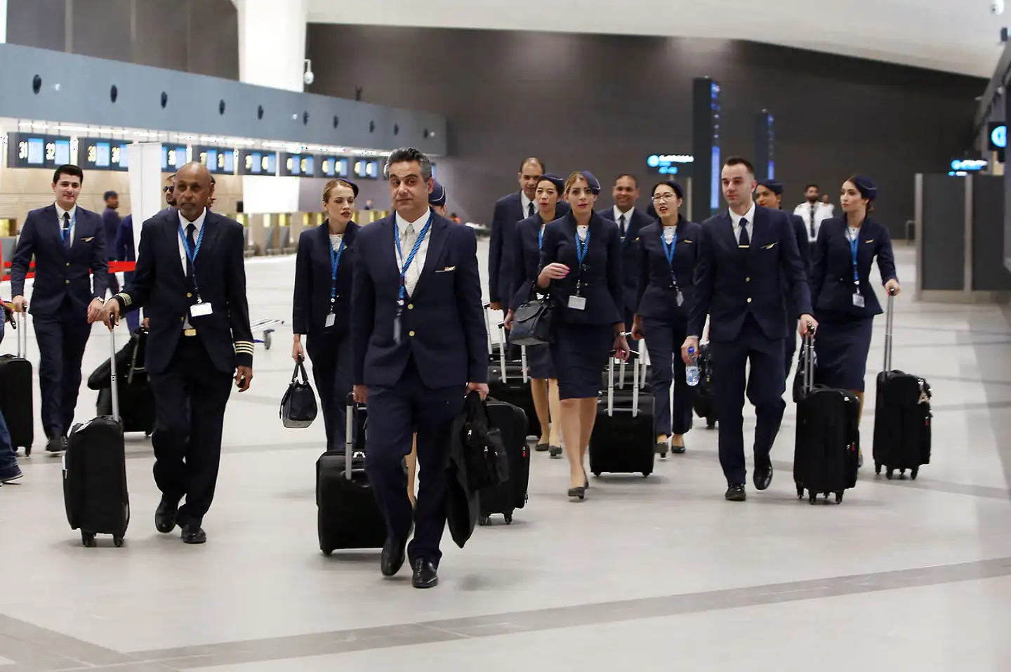 Besætningsmedlemmer fra Kuwait Airways på vej gennem en af terminalerne i Golf-landets Kuwait International Airport.