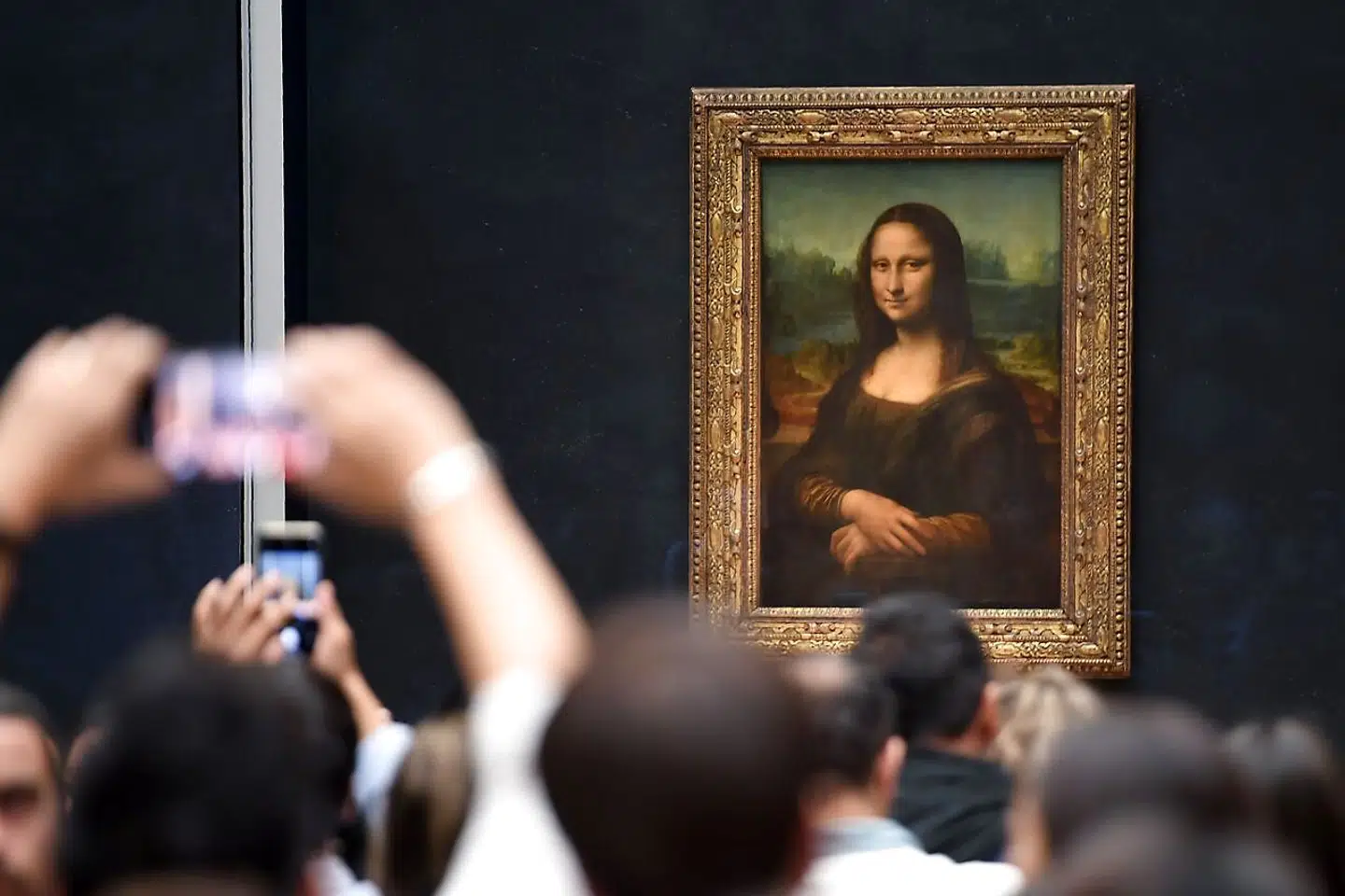 Besøgende står på nakken af hinanden for at se Leonardo da Vincis »Mona Lisa« på Louvre i Paris. Nu forøger museet at tage toppen af de daglige besøgstal og dermed skabe bedre plads.