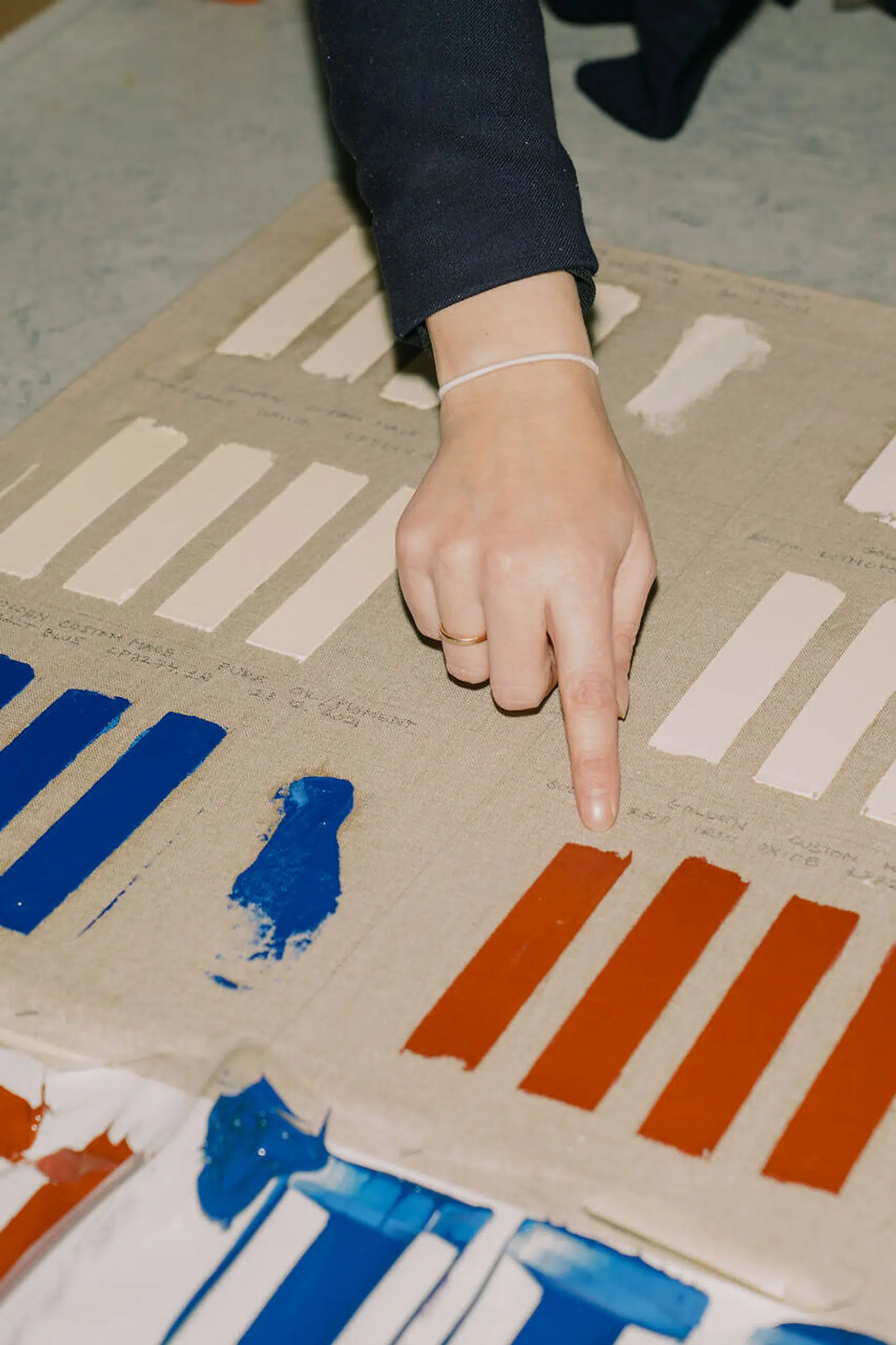 Lektor Cecil Krarup Andersen peger på nogle af de farveprøver, som har været brugt i forskning i farvers nedbrydning over tid.