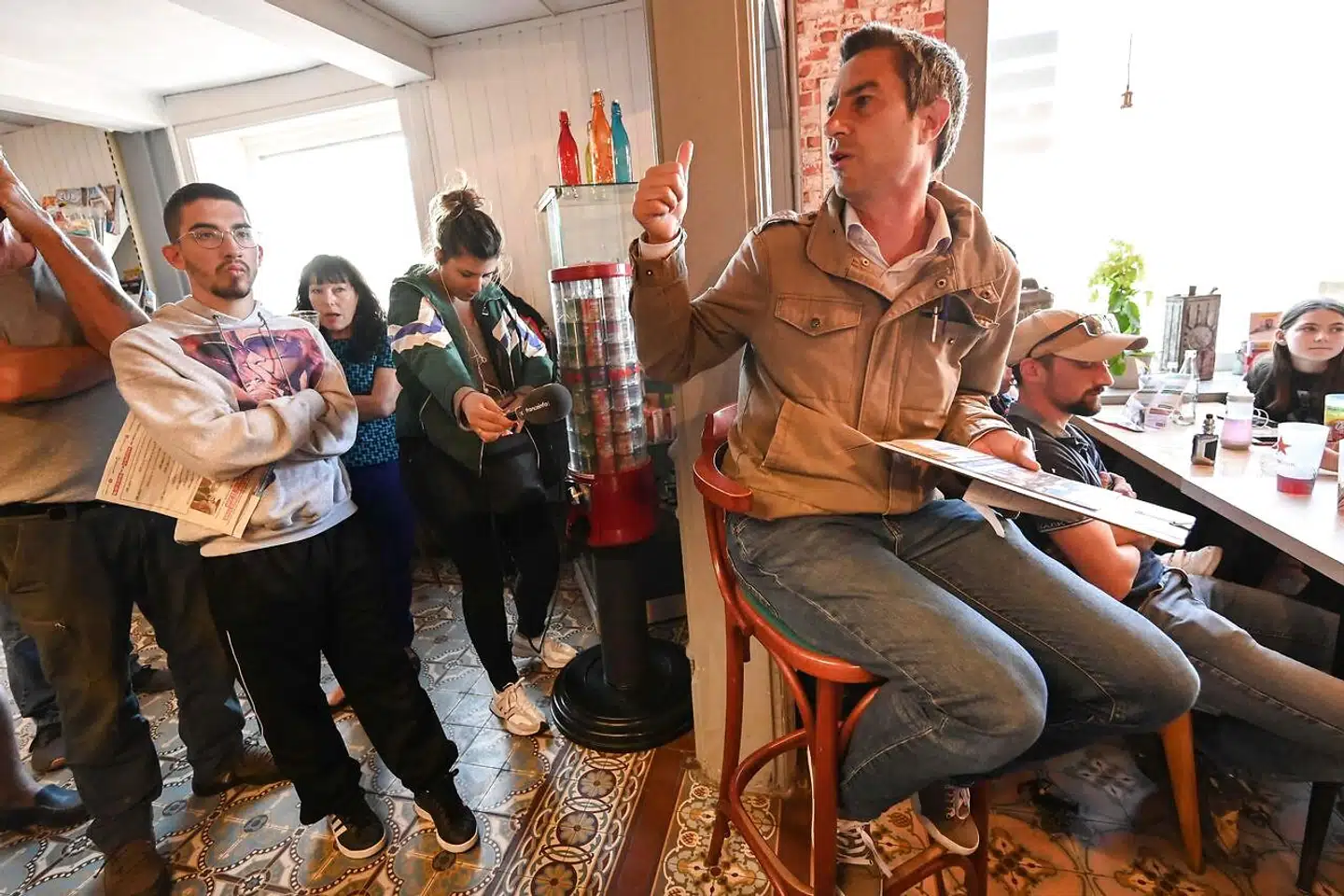 For François Ruffin er det vigtigt at være i øjenhøjde med sine vælgere, som her under et valgmøde på Café de l'Avenir i den lille by Condé-Folie. Det er under samtaler ved baren over en øl – langt fra de parisiske saloner – at han får sandheden at høre.