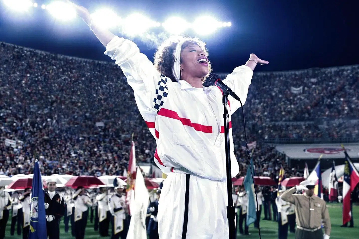 USA var dybt begravet i Golf-krigen, da den 27-årige Whitney Houston blev bedt om at stå for den årlige version af nationalsangen »The Star-Spangled Banner« under Super Bowl i 1991. For den utrænede sanger er det en af de sværeste nationalsange i verden, men med sin ubesværede stemme blev den et slags varemærke for Houston. Billede fra filmen »I Wanna Dance With Somebody«.