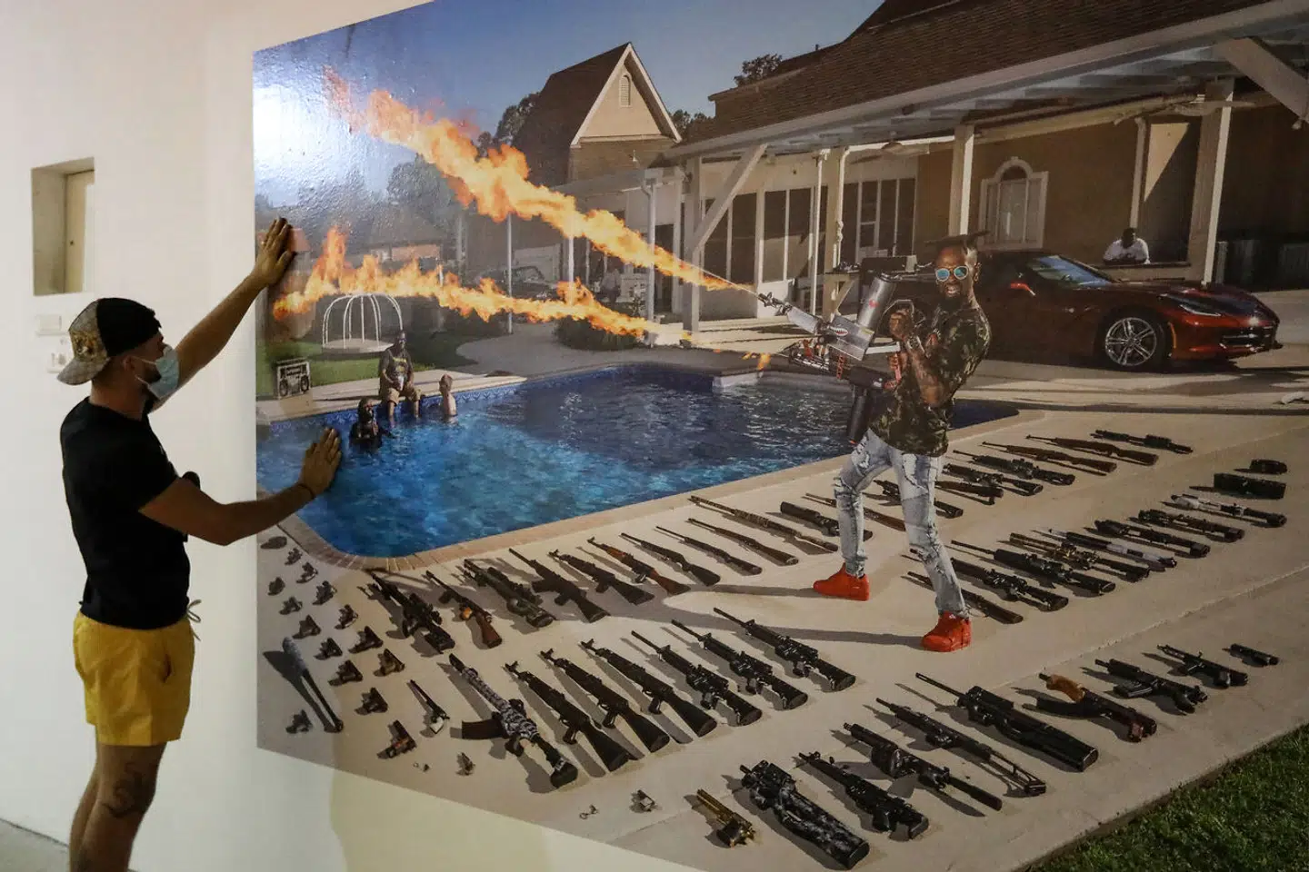 I et andet projekt, »The Ameriguns«, udgivet i 2020 for National Geographic, fotograferede Gabriele Galimberti amerikanere over hele USA med deres personlige skydevåben. En kampagne, der også gik også viralt. Her en udstilling af billederne, hvor en ansat hænger billederne op.