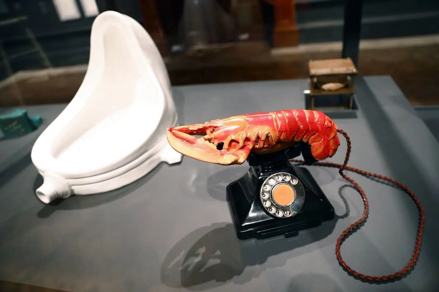 Det lader til, at Søren Jacobsen Damm opfatter Kunstnernes Efterårsudstilling 2022 som værende i direkte forlængelse af Duchamps projekt, skriver Thor Tao Hansen, der er billedkunstner og selv har et værk med på udstillingen. Billede af Marcel Duchamps 'Fountain' fra 1917 (tv.) og Salvador Dalis »hummertelefon« fra 1938.